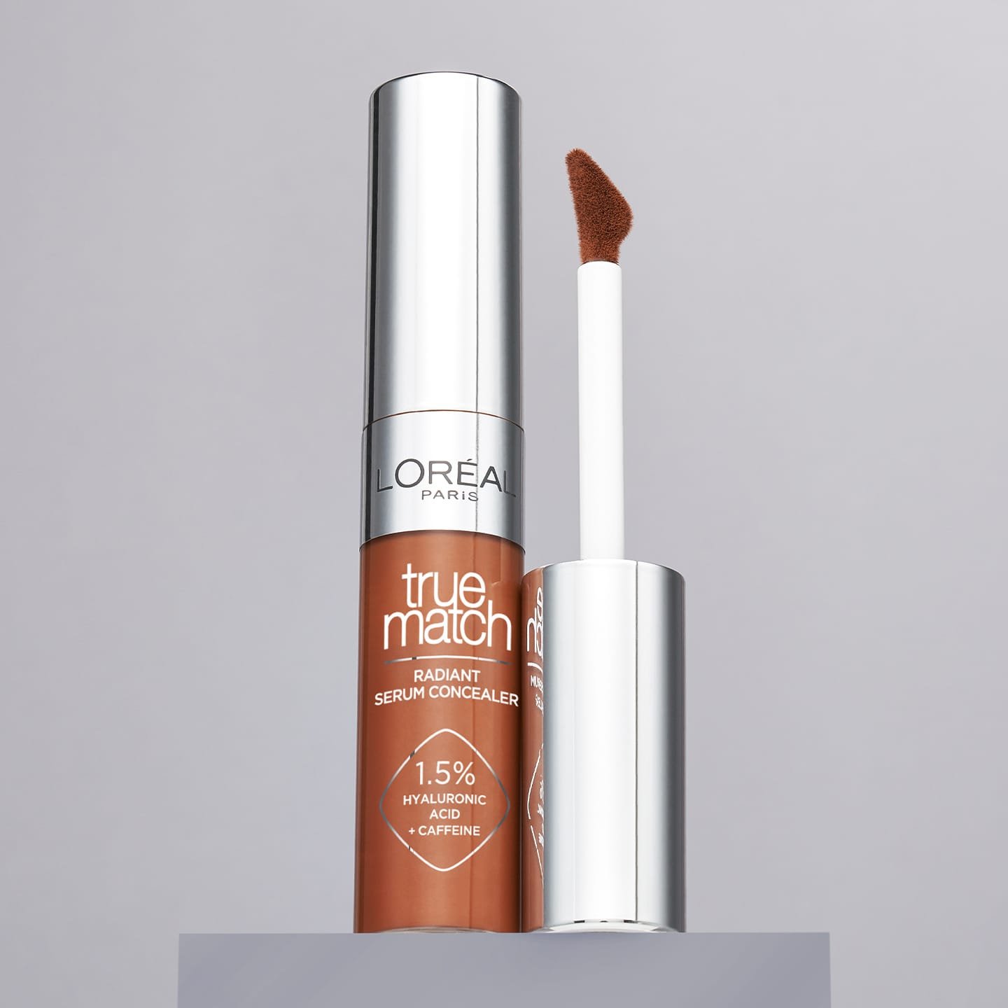 Eine Nuance von True Match Radiant Serum Concealer geöffnet auf einem grauen Sockel